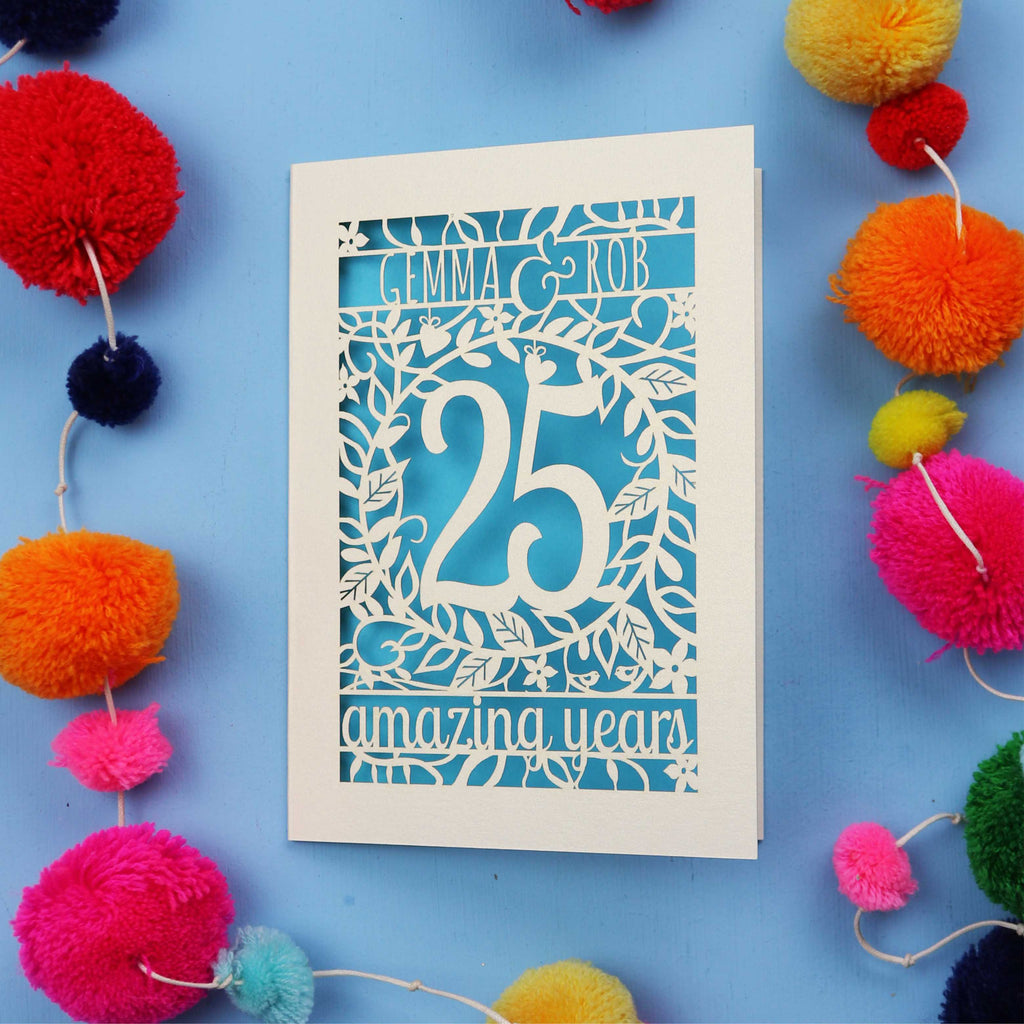 Silver wedding anniversary Card with '25 amazing years' text on a blue background with colourful pom-poms.