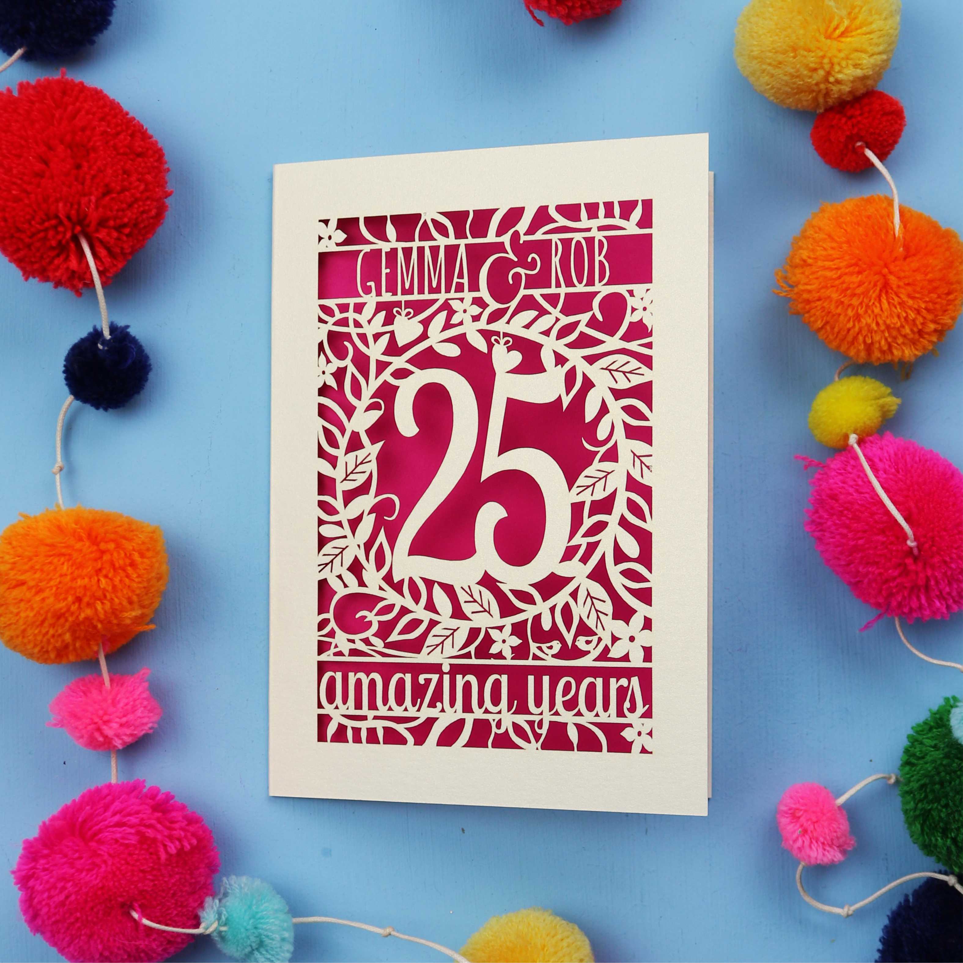 Silver wedding anniversary Card with '25 amazing years' text on a blue background with colourful pom-poms.