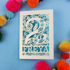 Decorative second birthday card with 'FREYA' design on a blue background with colourful pom-poms.