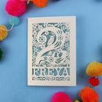 Laser cut 2nd birthday card with woodland design on a blue background with colourful pom-poms.