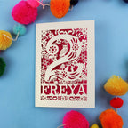 Decorative 2nd birthday card with 'FREYA' design on a blue background with colourful pom-poms.