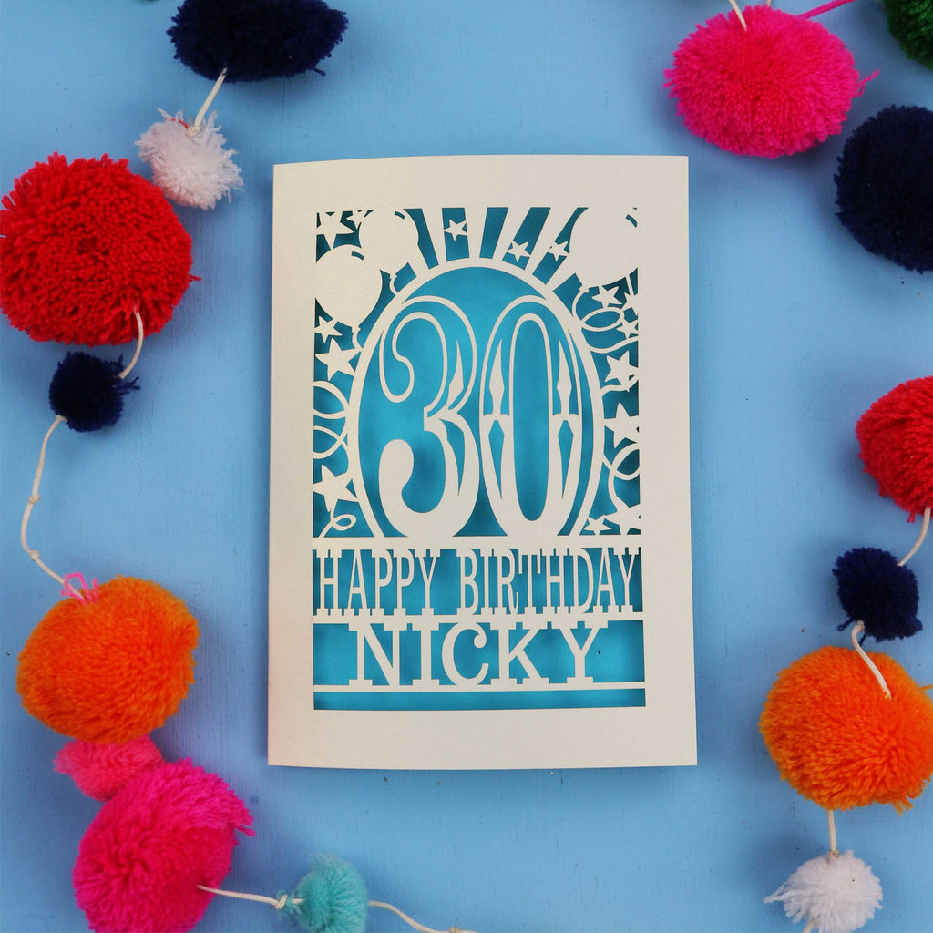 30th Birthday card with 'Happy Birthday Nicky' on a blue background with colourful pom-poms.