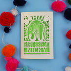 30th Birthday card with 'Happy Birthday Nicky' on a blue background with colourful pom-poms.