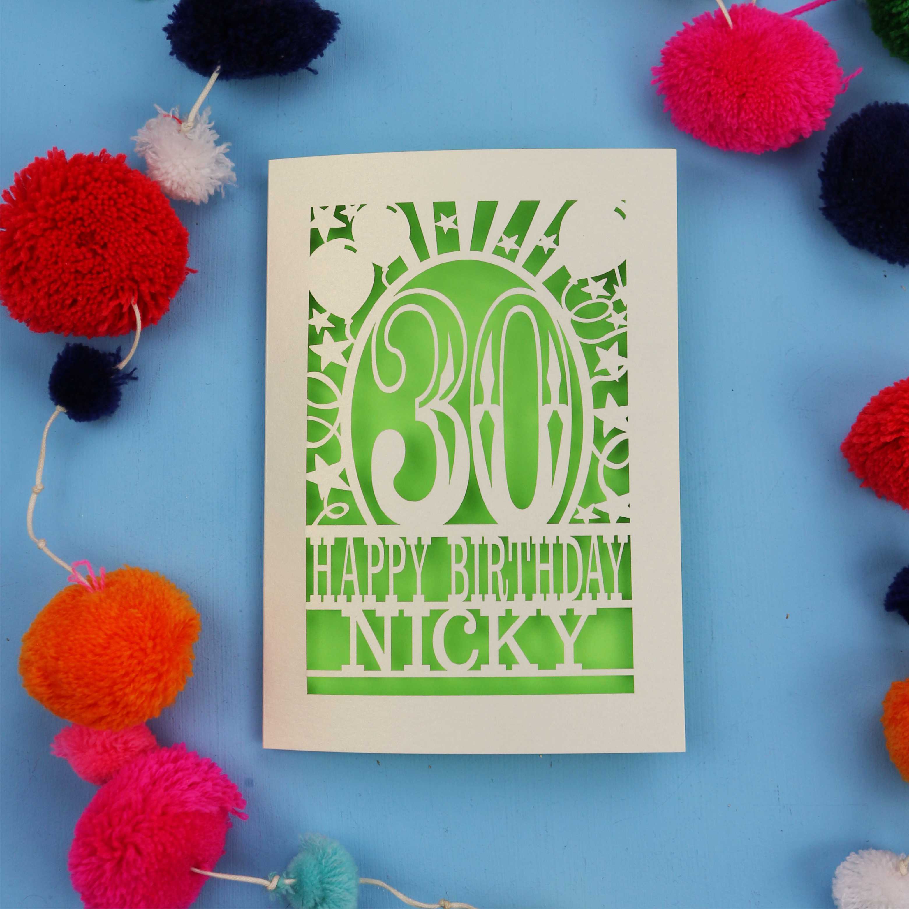 30th Birthday card with 'Happy Birthday Nicky' on a blue background with colourful pom-poms.