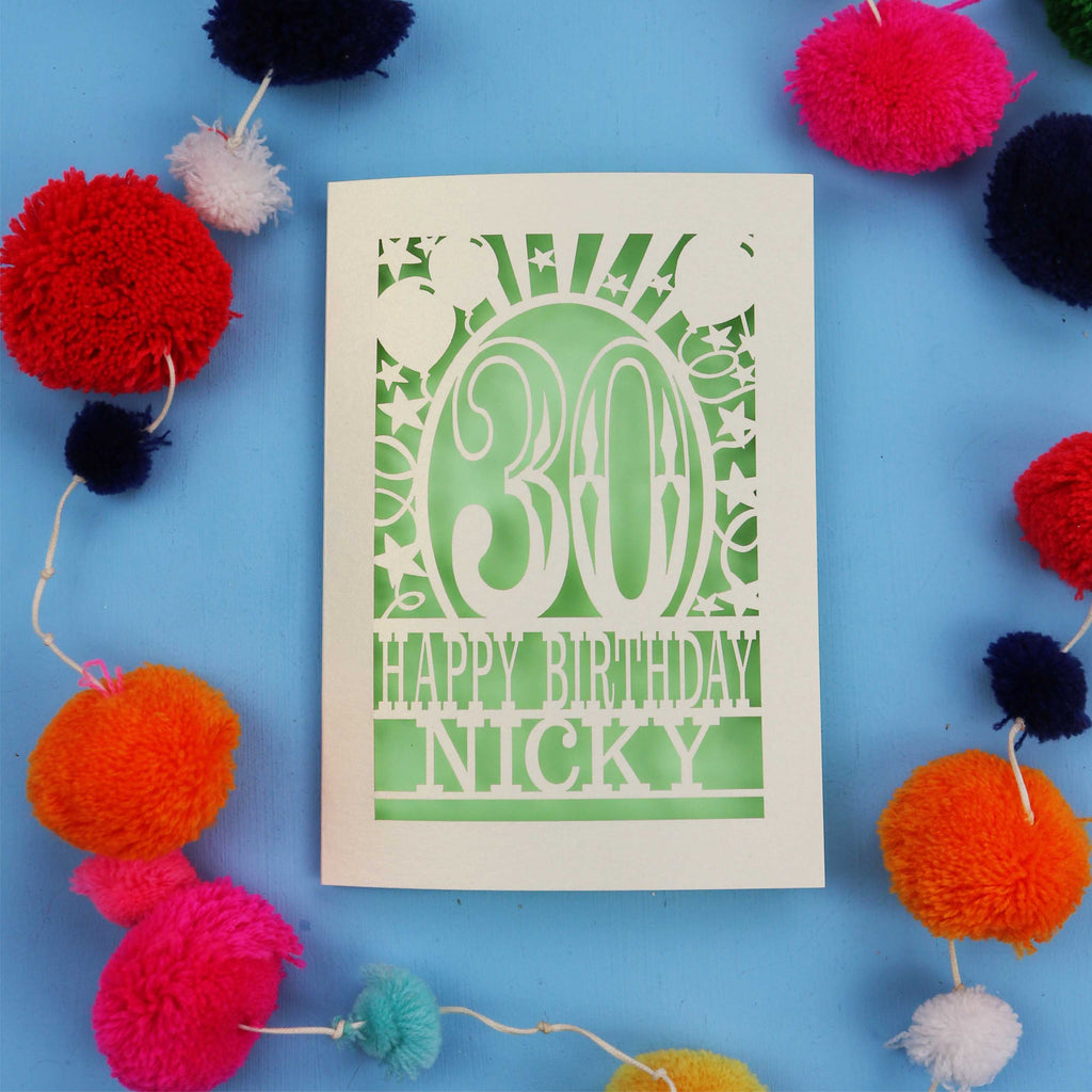 30th Birthday card with 'Happy Birthday Nicky' on a blue background with colourful pom-poms.