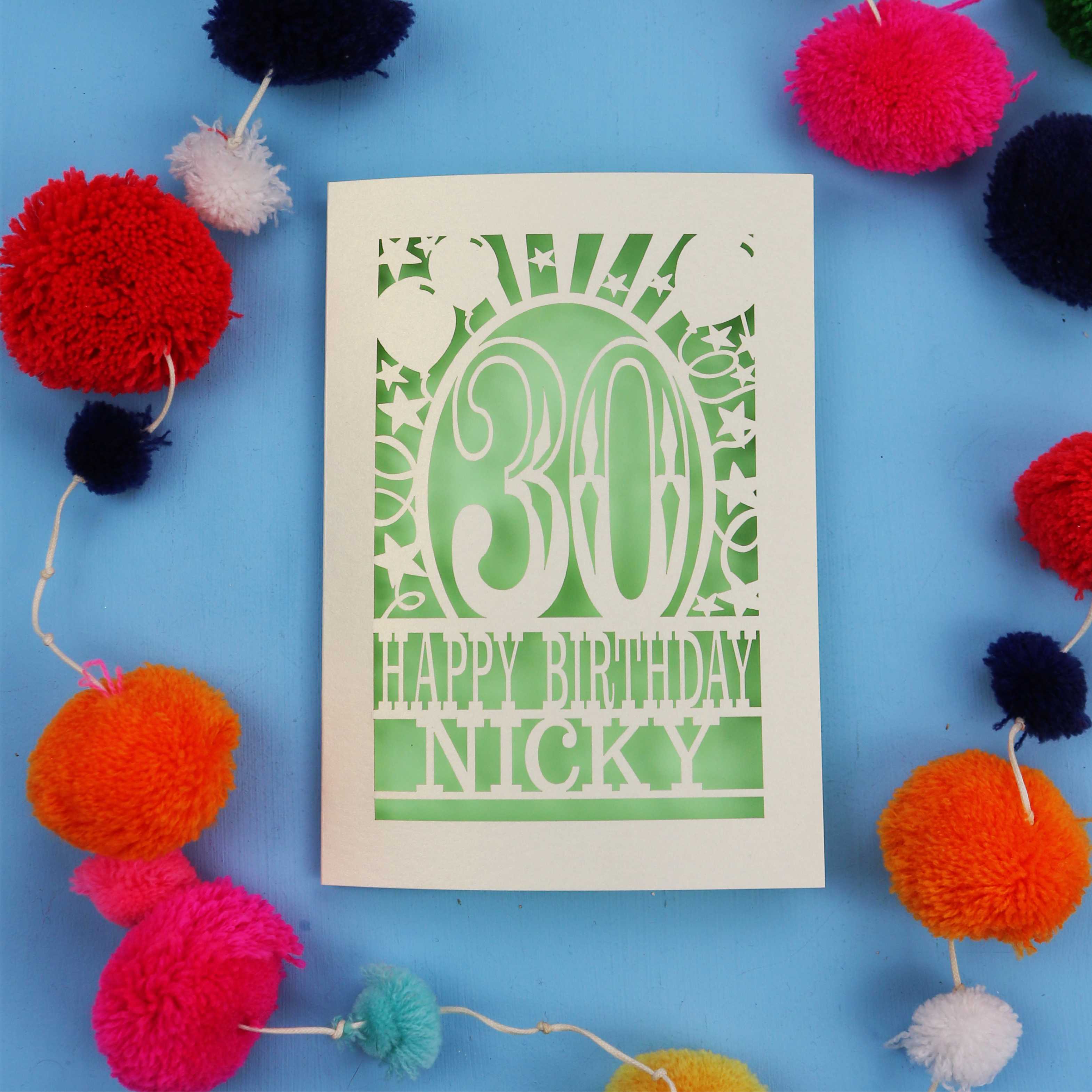 30th Birthday card with 'Happy Birthday Nicky' on a blue background with colourful pom-poms.