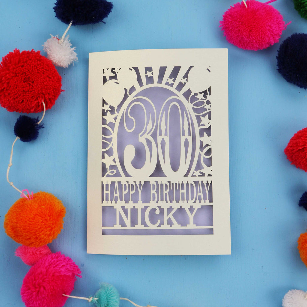 30th Birthday card with 'Happy Birthday Nicky' on a blue background with colourful pom-poms.