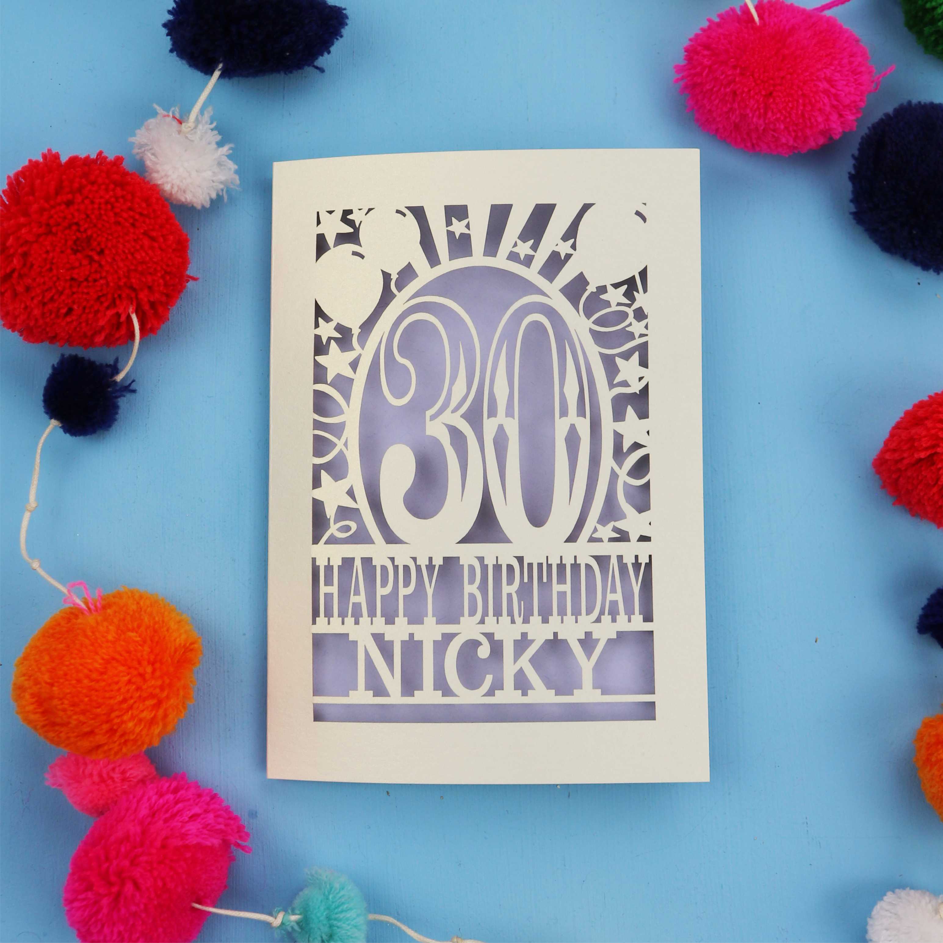30th Birthday card with 'Happy Birthday Nicky' on a blue background with colourful pom-poms.