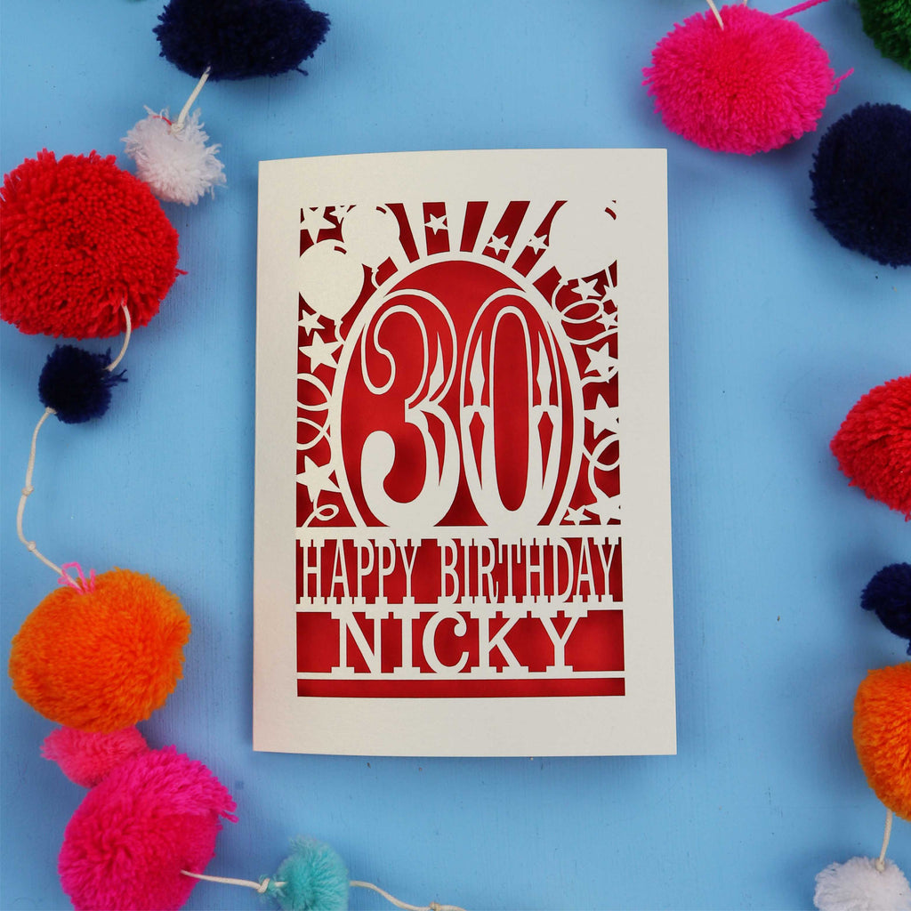 30th Birthday card with 'Happy Birthday Nicky' on a blue background with colourful pom-poms.
