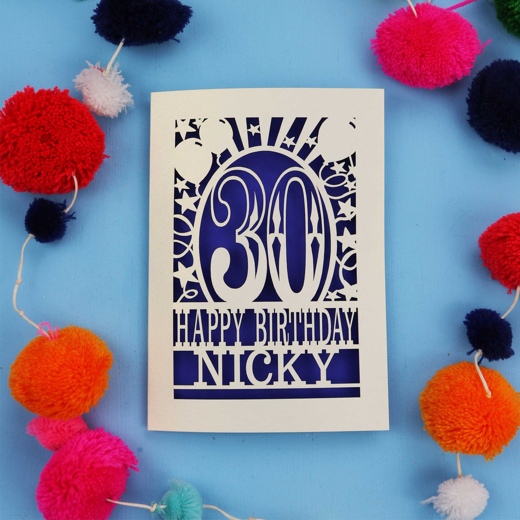 30th Birthday card with 'Happy Birthday Nicky' on a blue background with colourful pom-poms.
