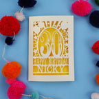 30th Birthday card with 'Happy Birthday Nicky' on a blue background with colourful pom-poms.