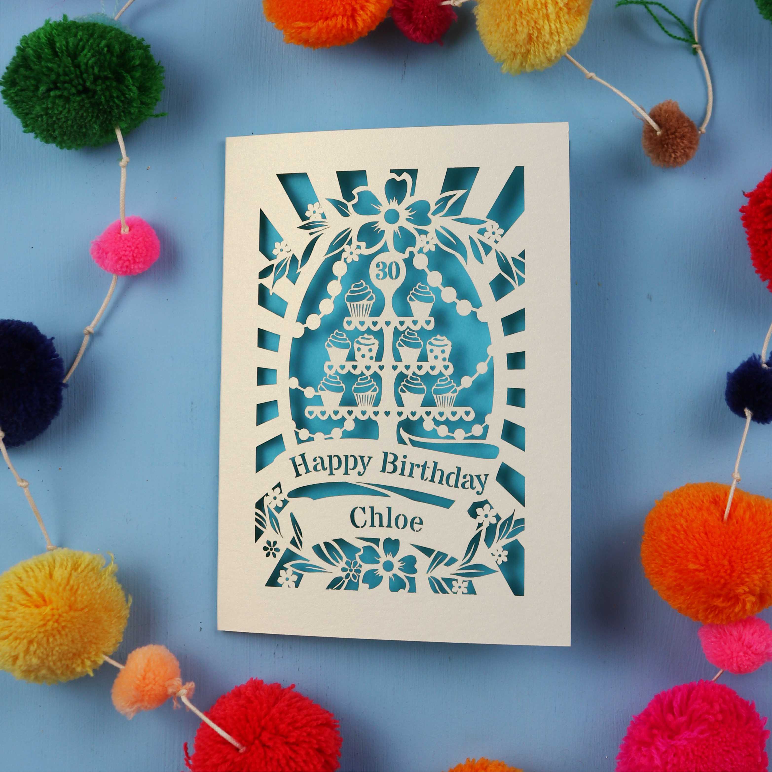 Decorative 30th birthday card with colourful pom-poms on a blue 