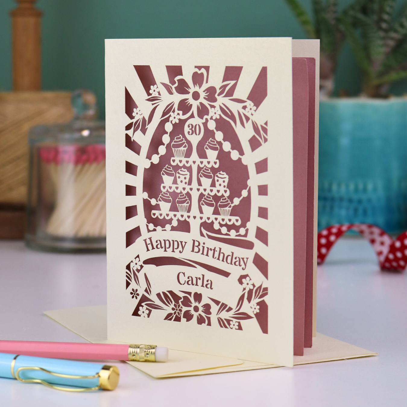 Personalised 30th birthday card with decorative laser cut cupcake design on a table with stationery items.
