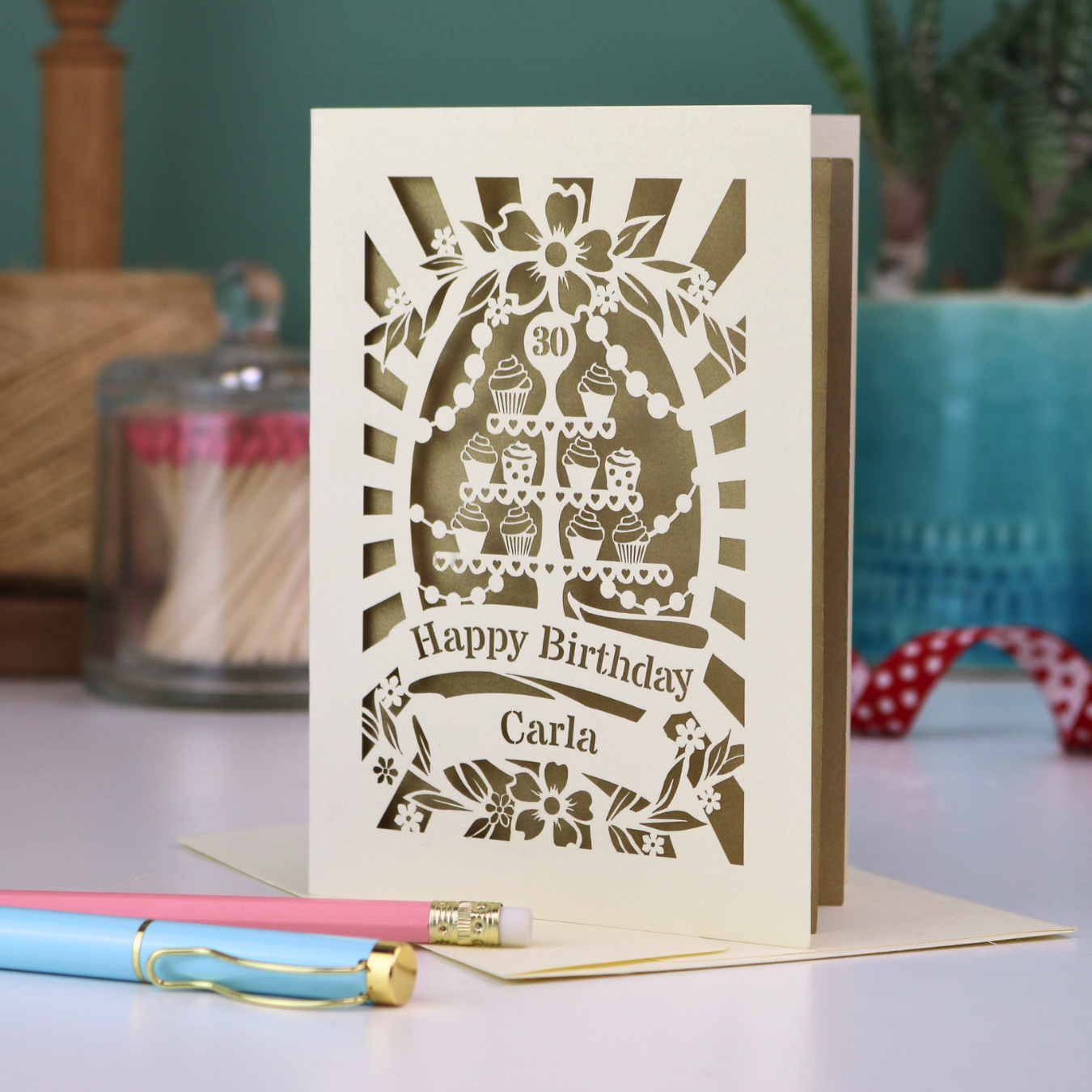 Personalised 30th birthday card with decorative laser cut cupcake design on a table with stationery items.