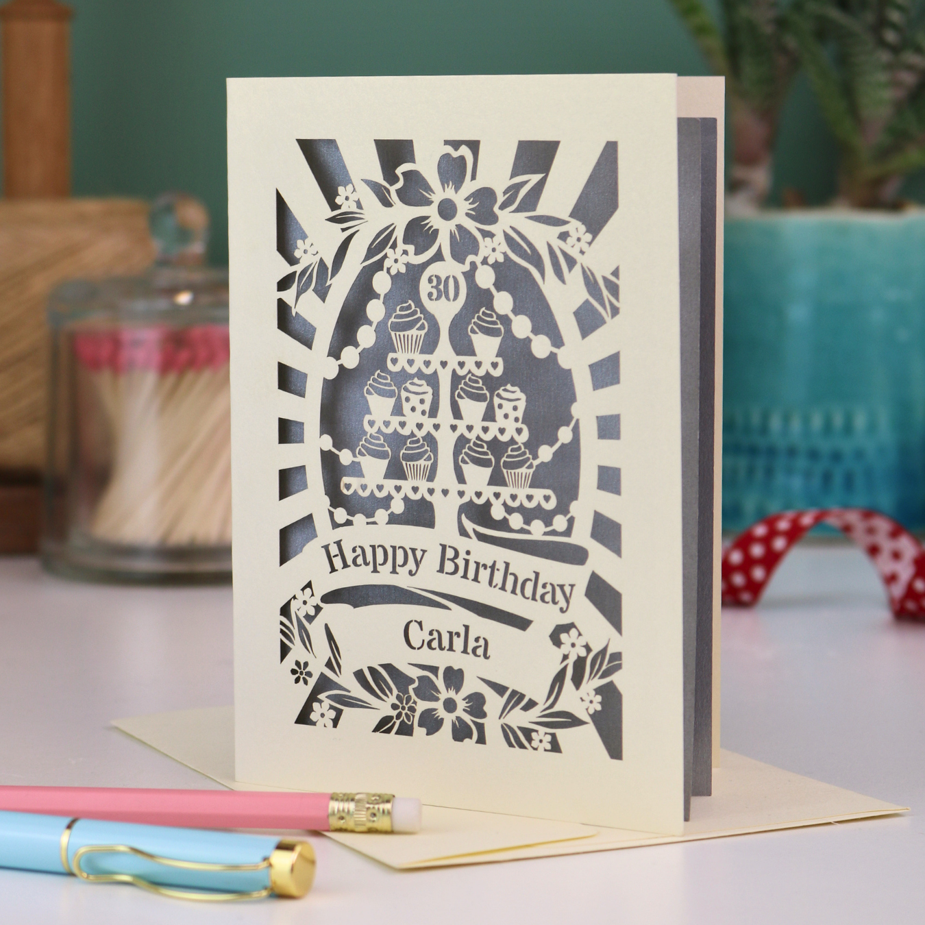 Personalised 30th birthday card with decorative laser cut cupcake design on a table with stationery items.