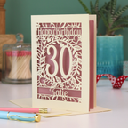 A laser cut 30th birthday card with floral cut out design, "Happy Birthday", 30, and personalised with a name. 