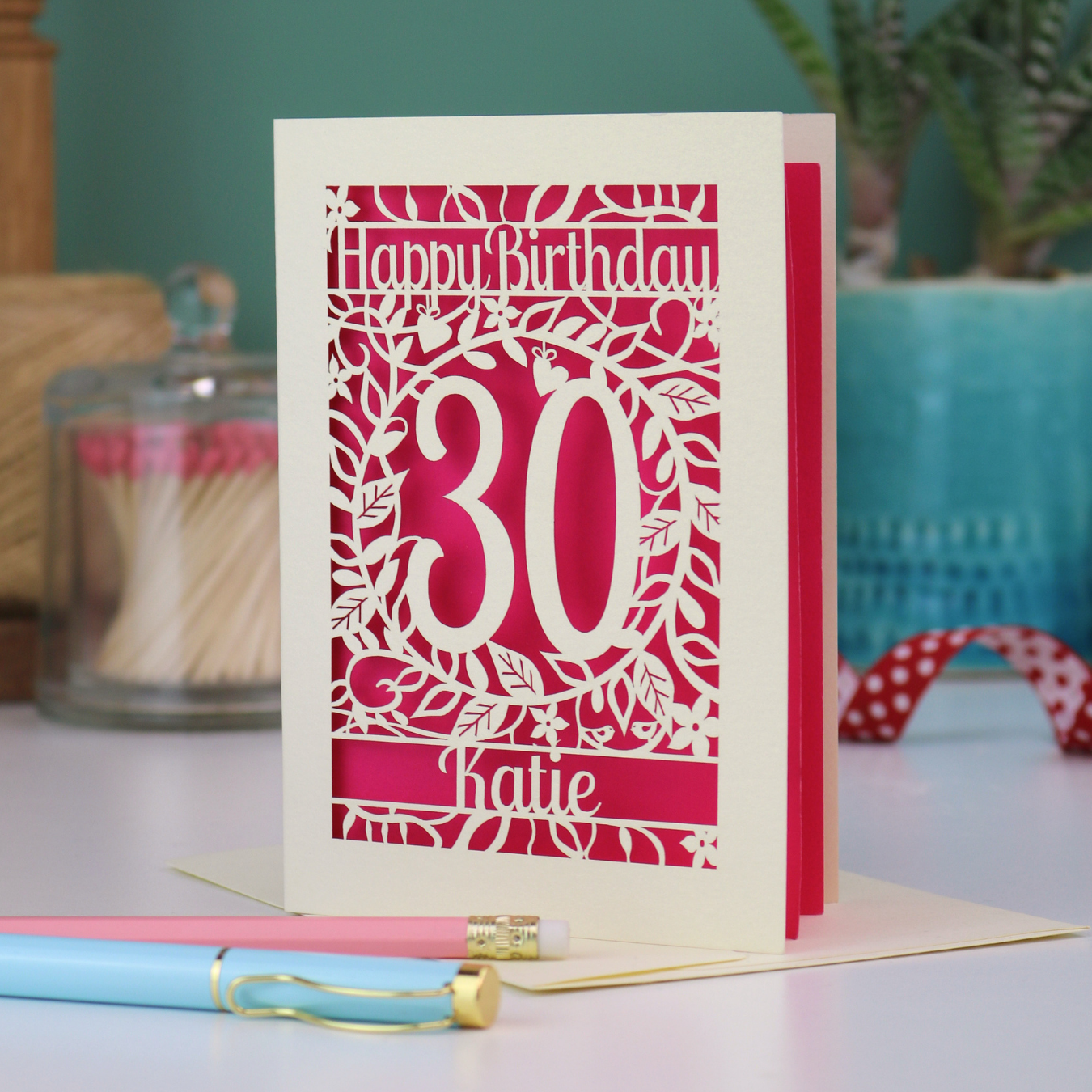 A laser cut 30th birthday card with floral cut out design, "Happy Birthday", 30, and personalised with a name. 