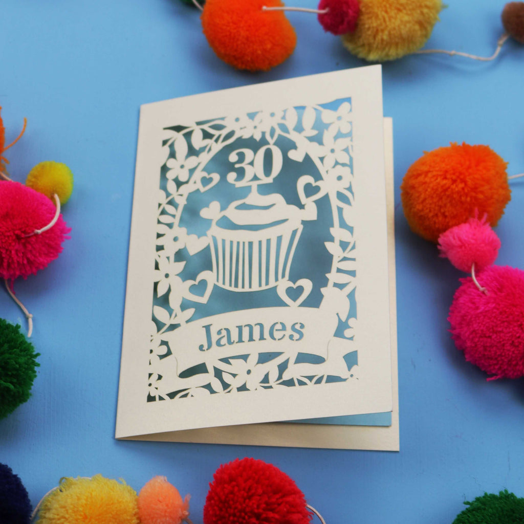 30th Birthday Card with '30 James' design on a blue background with colourful pom-poms.