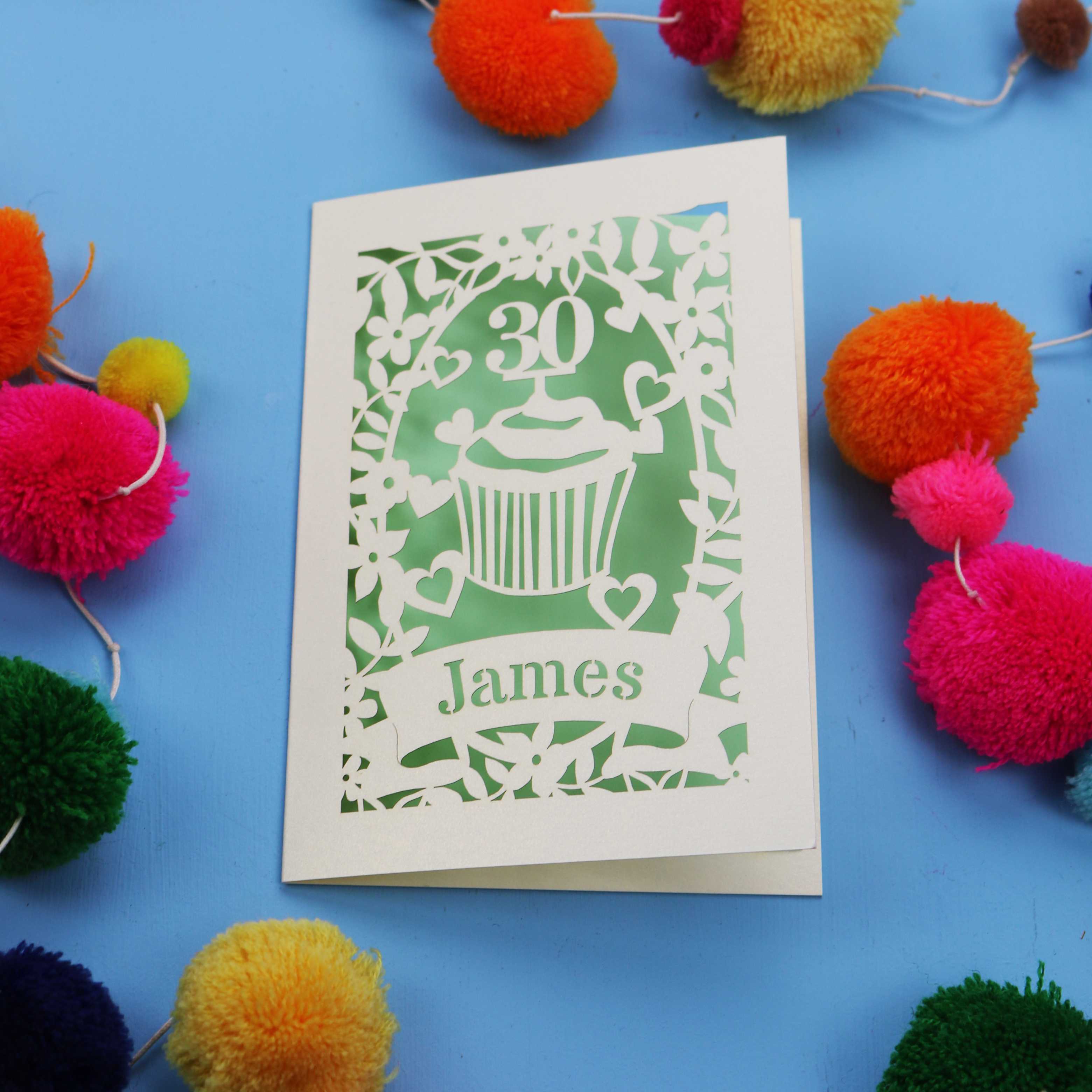30th Birthday Card with '30 James' design on a blue background with colourful pom-poms.