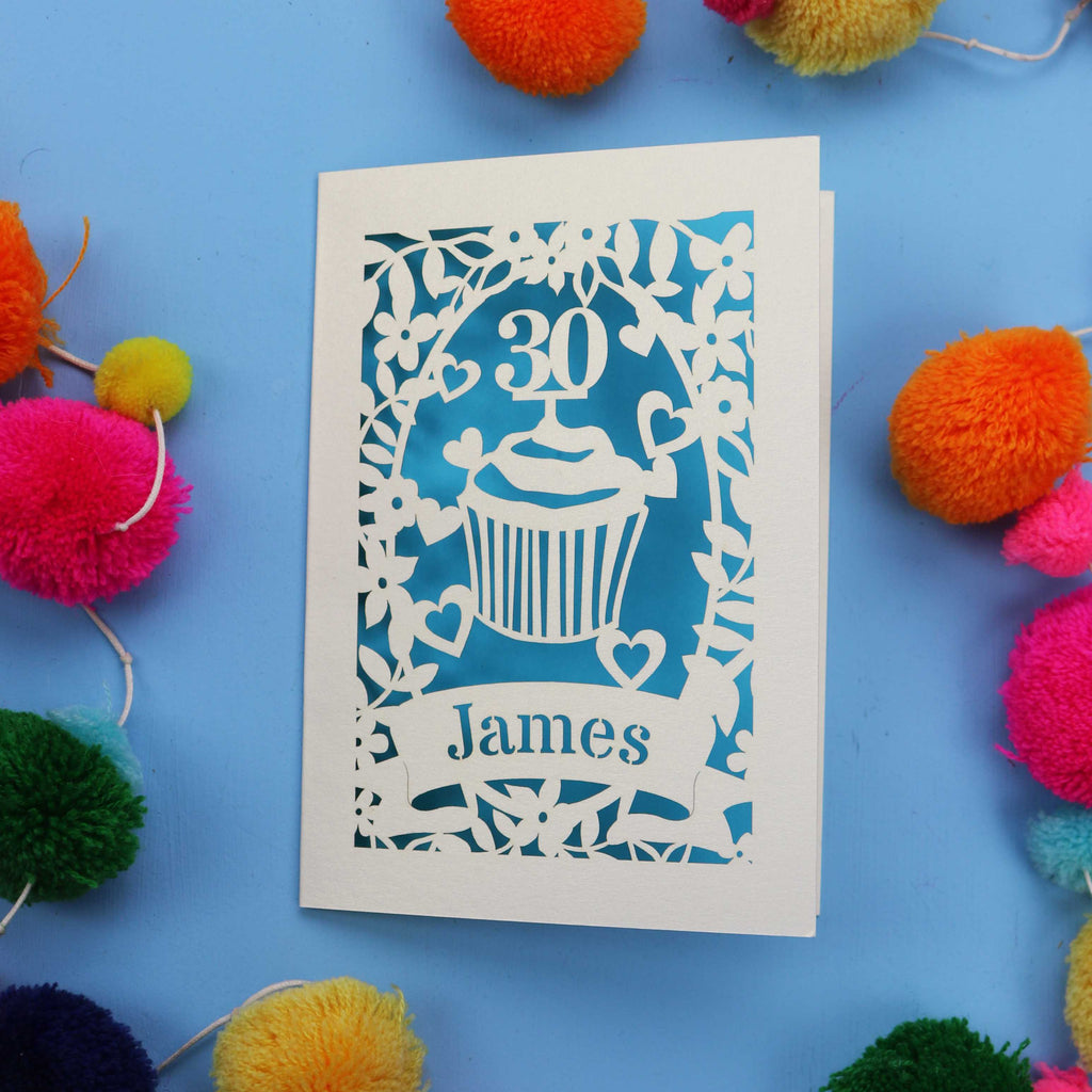 30th Birthday Card with '30 James' design on a blue background with colourful pom-poms.