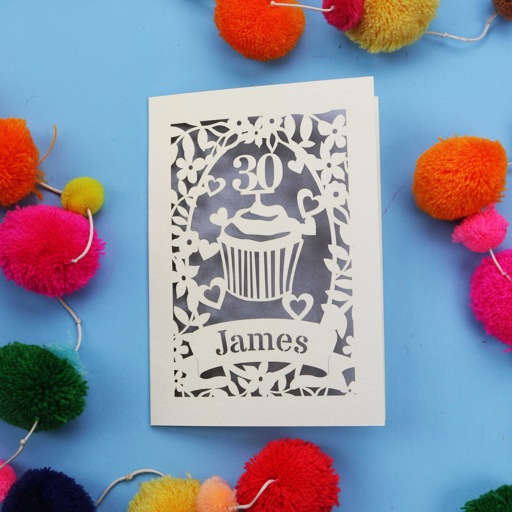30th Birthday Card with '30 James' design on a blue background with colourful pom-poms.