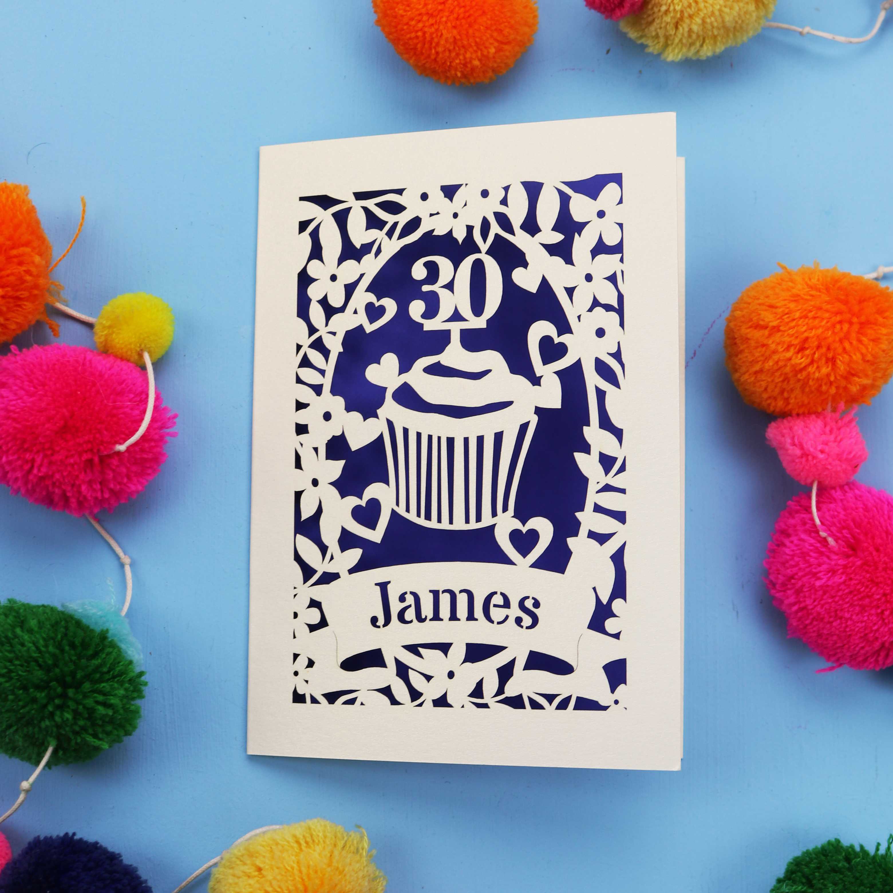 30th Birthday Card with '30 James' design on a blue background with colourful pom-poms.