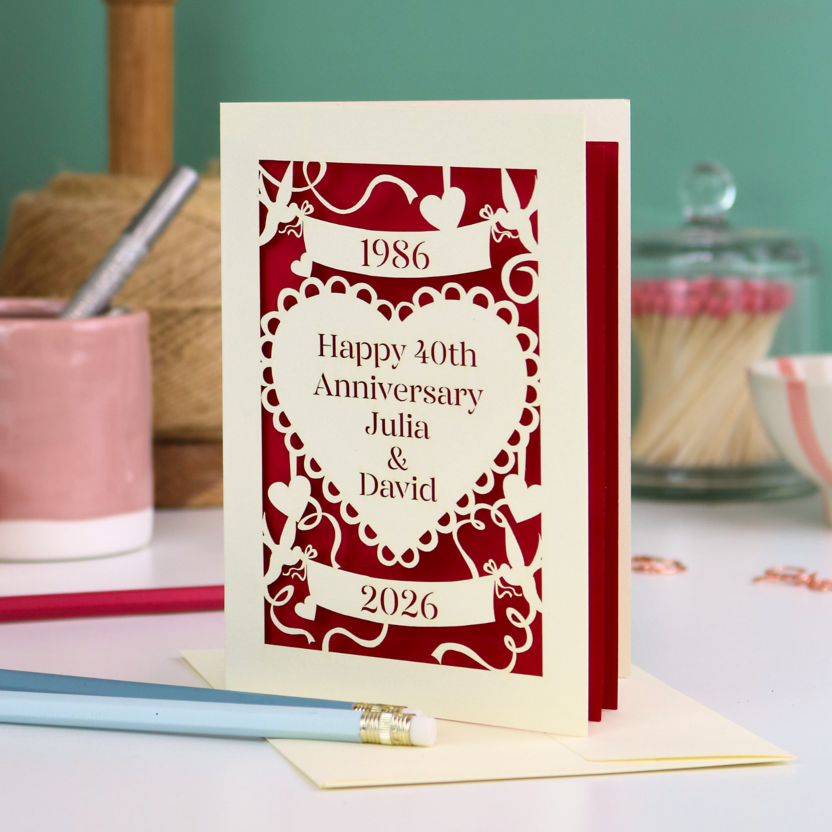 40th anniversary card with decorative border on a table with stationery items.
