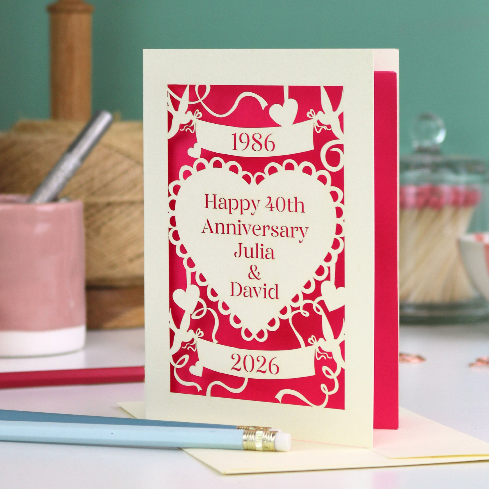 40th anniversary card on a table with stationery items.