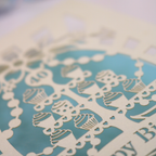 Decorative paper cutout with cupcake design on a blue background