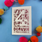 Woodland themed 4th birthday card with number '4' and 'OLIVE' text on a blue background with colourful pom-poms.