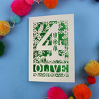 Woodland themed personalised 4th birthday card with number '4' and 'OLIVE' text on a blue background with colourful pom-poms.