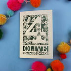 Woodland 4th birthday card with number '4' and 'OLIVE' text on a blue background with colourful pom-poms.