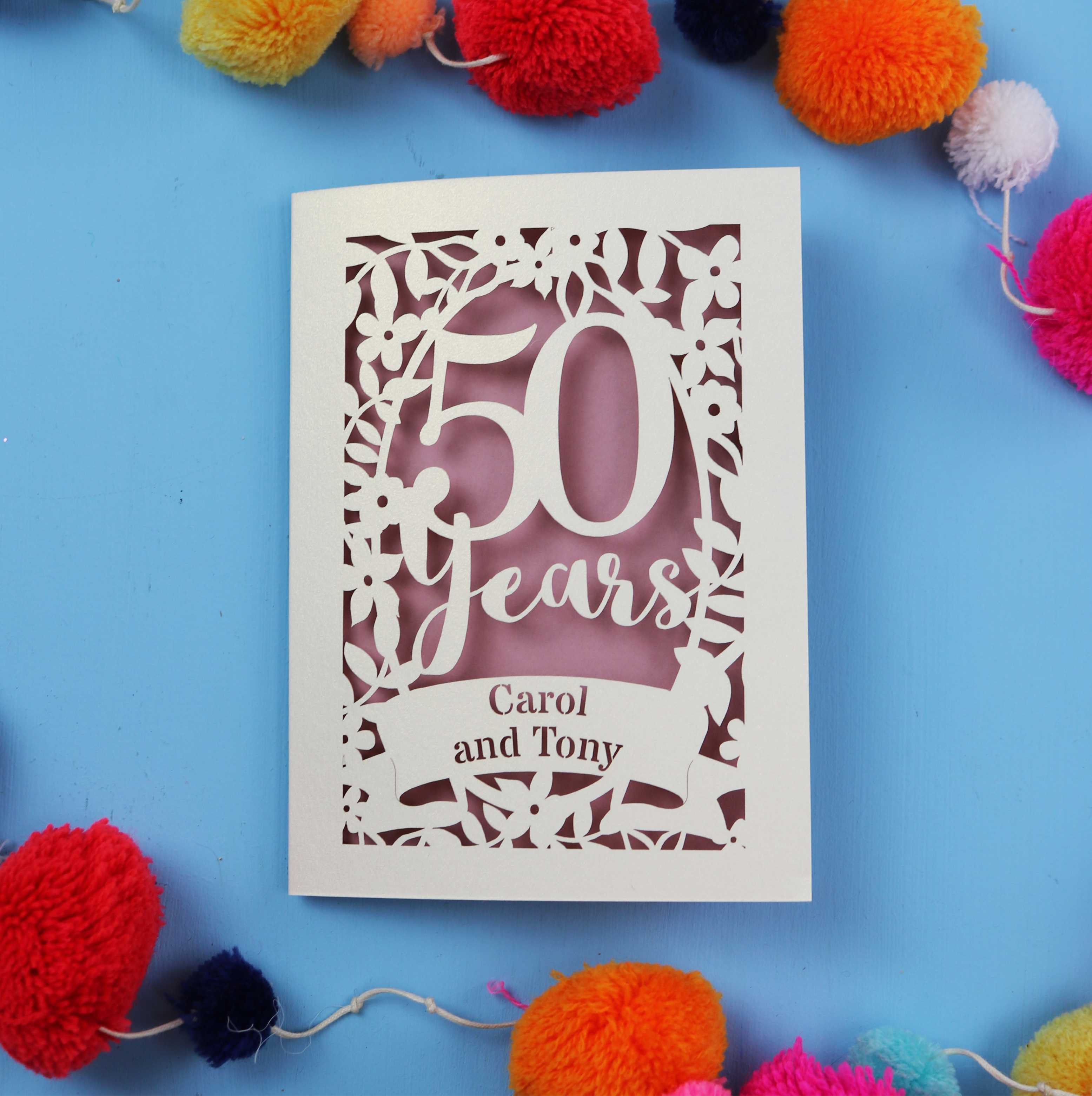 50th Wedding anniversary Card with '50 Years Carol and Tony' on a blue background with colourful pom-poms.