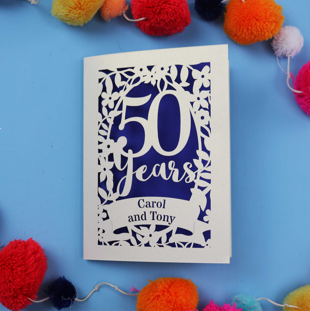 50th anniversary Card with '50 Years Carol and Tony' on a blue background with colourful pom-poms.