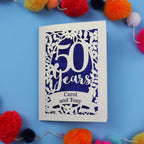 50th anniversary Card with '50 Years Carol and Tony' on a blue background with colourful pom-poms.