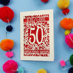 50th Anniversary Card with '50 amazing years' design on a blue background with colourful pom-poms.
