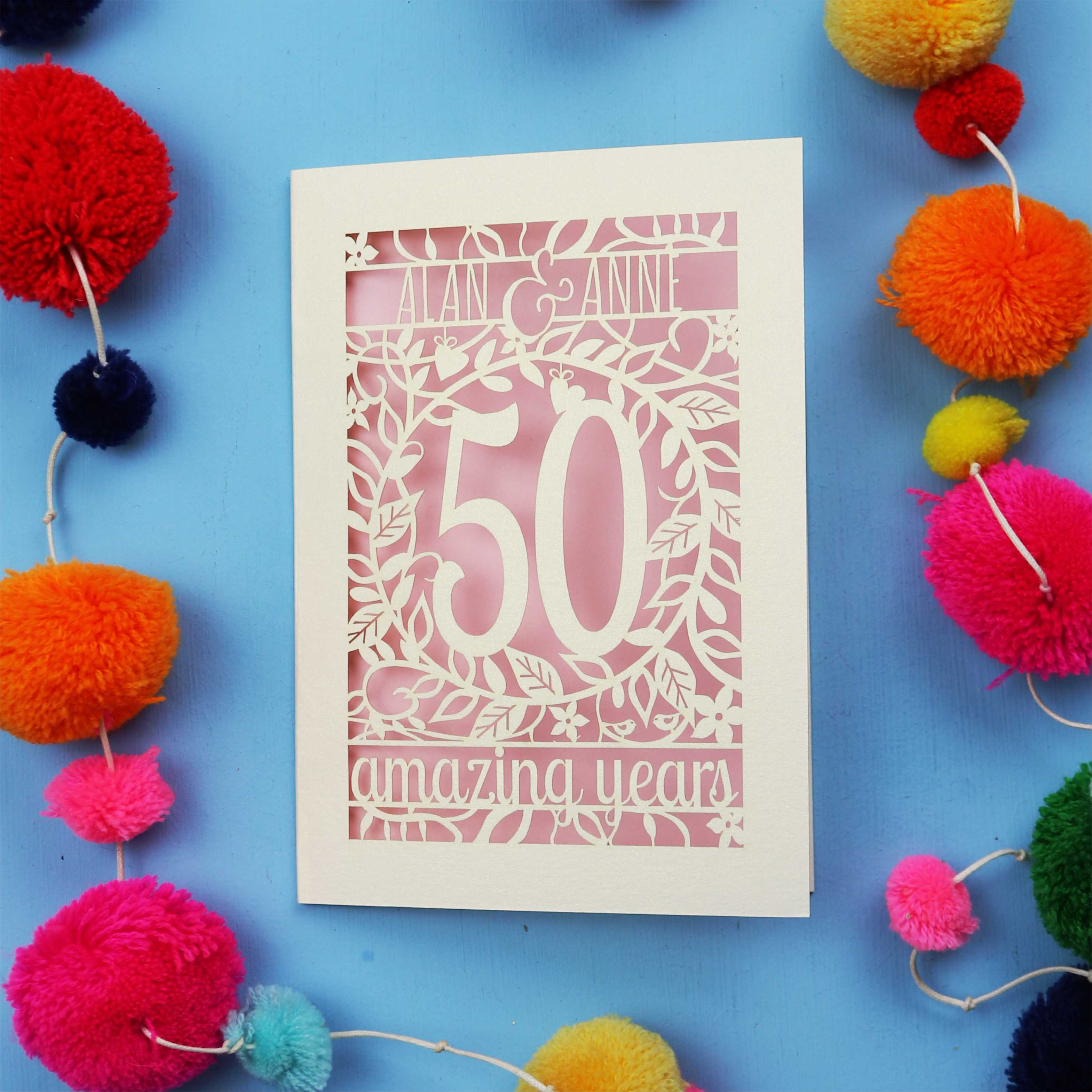 50th wedding Anniversary Card with '50 amazing years' design on a blue background with colourful pom-poms.