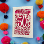 50th Anniversary Card with '50 amazing years' design on a blue background with colourful pom-poms.