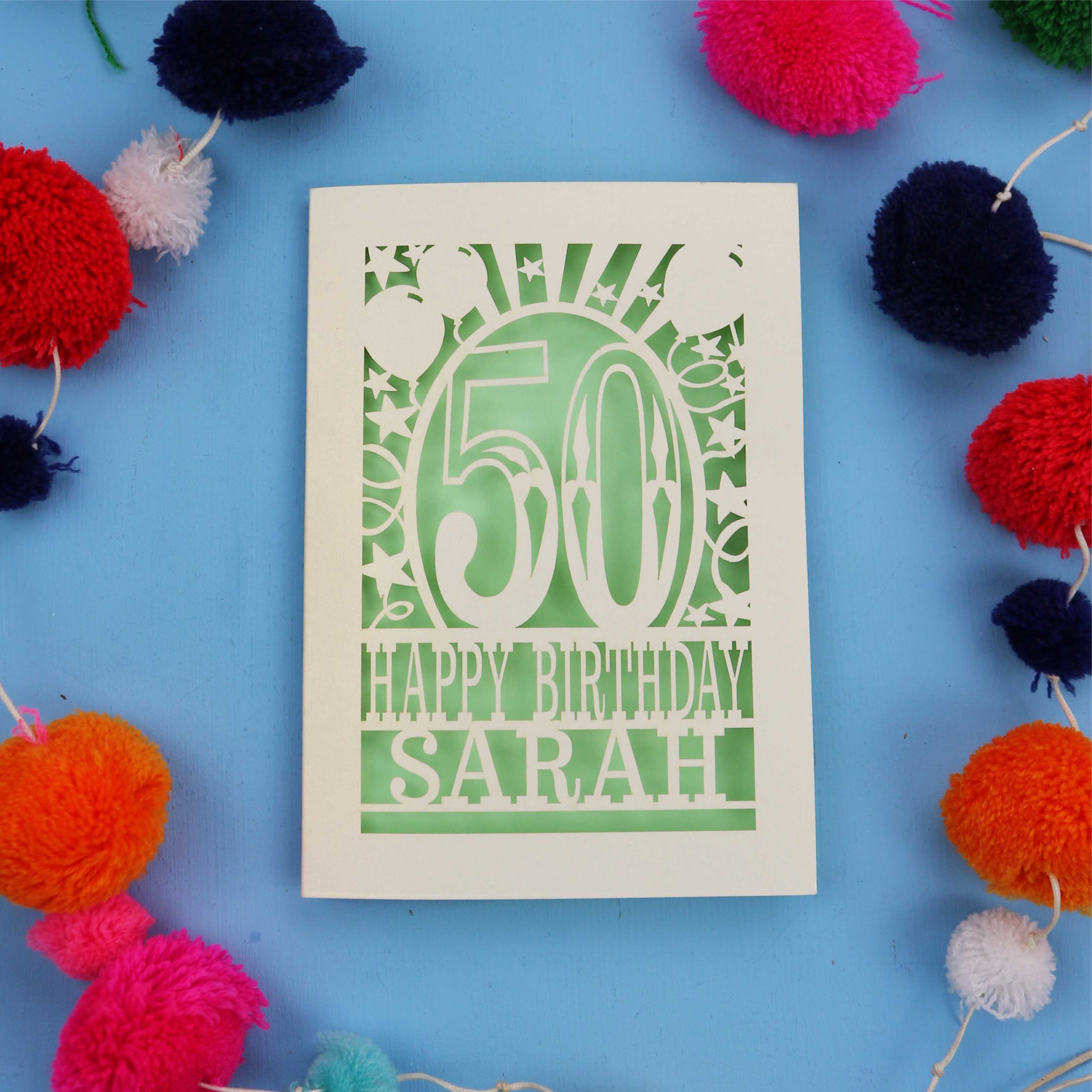 Personalised Happy 50th birthday card with colourful pom-poms on a blue background