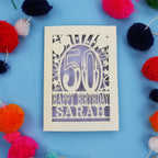 Laser cut Happy 50th birthday card with colourful pom-poms on a blue background