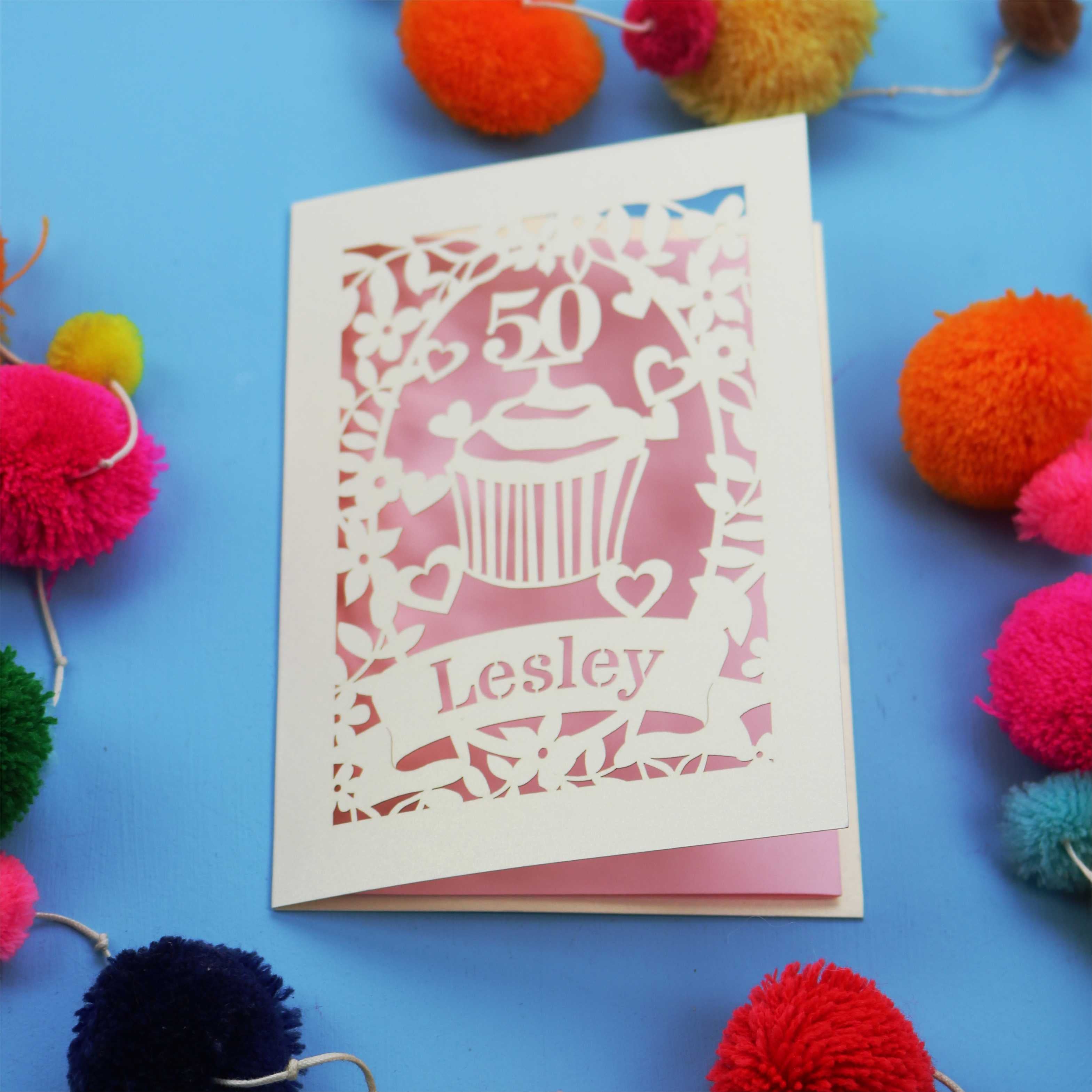 A 50th birthday Card with '50' and 'Lesley' on a blue background with colourful pom-poms