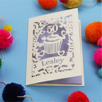 A 50th birthday Card with '50' and 'Lesley' on a blue background with colourful pom-poms