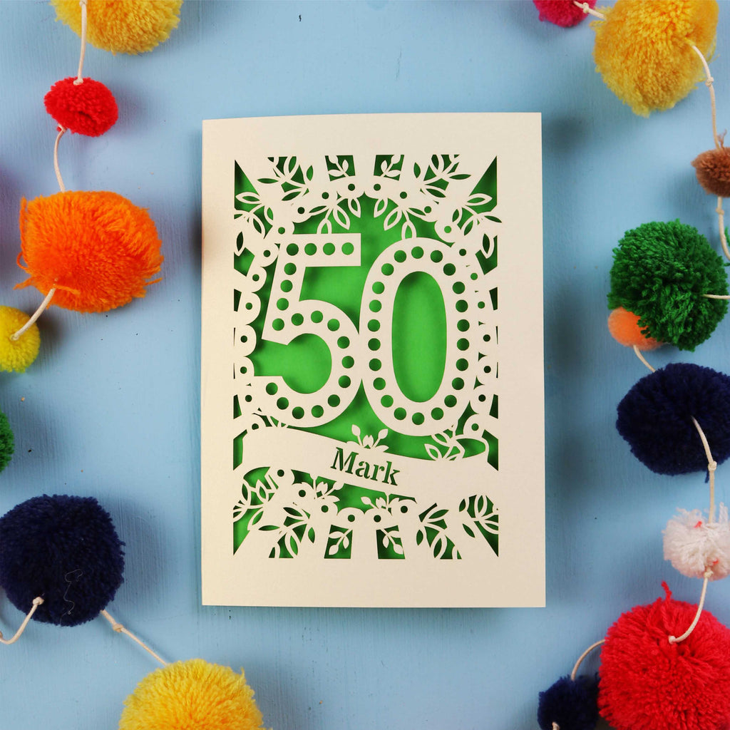 Laser Cut 50th Birthday Card with '50' design on a blue background with colourful pom-poms.