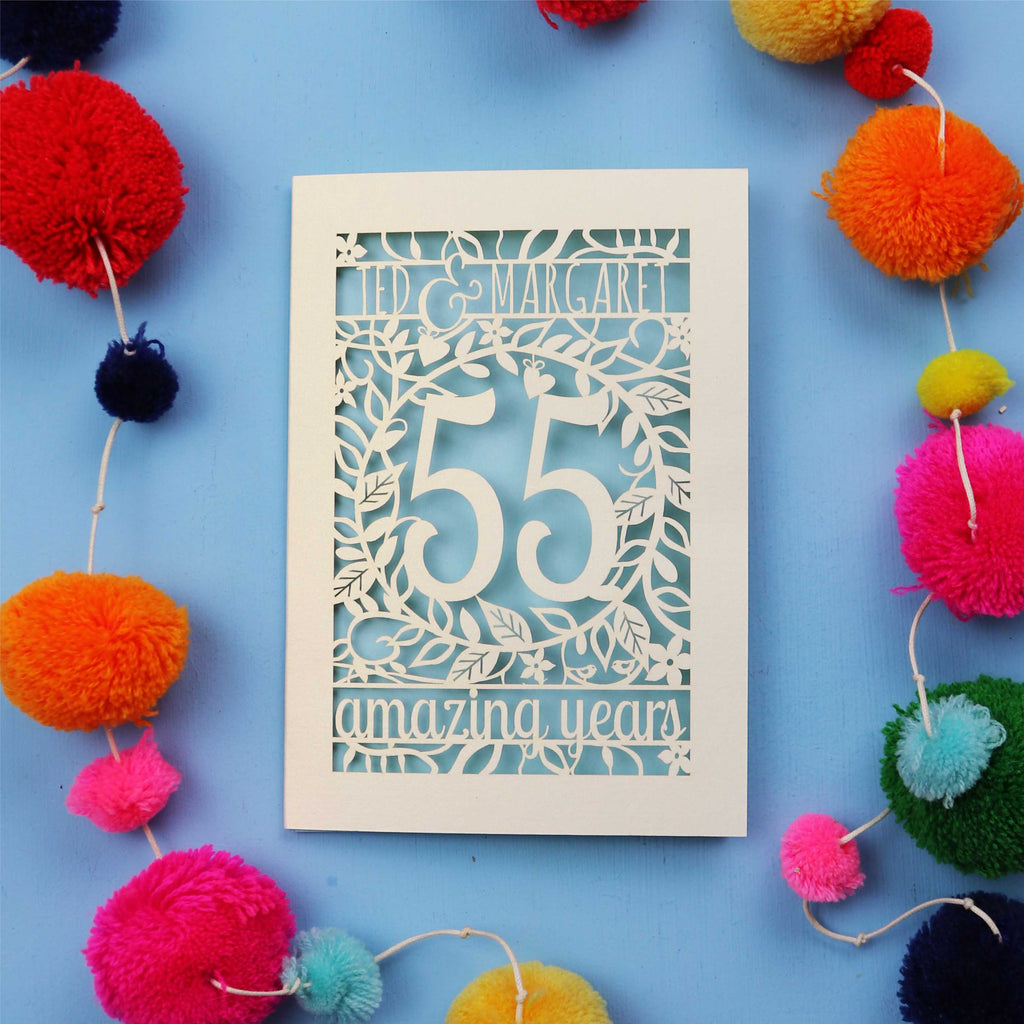 55th wedding anniversary Card with '55 amazing years' design on a blue background with colourful pom-poms.