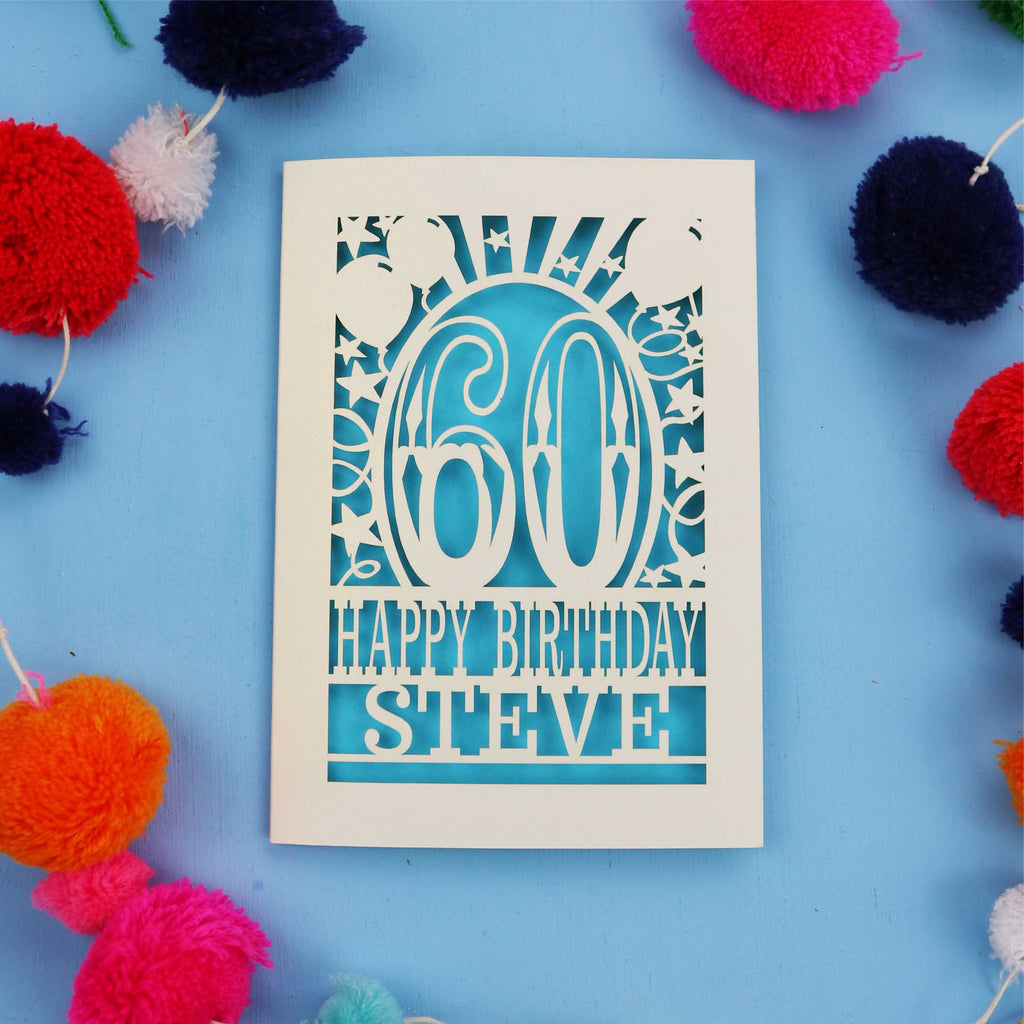 Laser cut Personalised 60th Birthday card with '60 Happy Birthday Steve' on a blue background with colourful pom-poms.