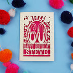 Personalised 60th Birthday card with '60 Happy Birthday Steve' on a blue background with colourful pom-poms.