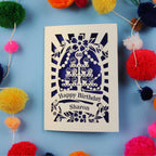 Laser Cut 60th Birthday card with personalized name surrounded by colourful pom-poms on a blue background
