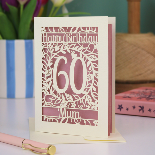 A laser cut 60th birthday card with cut out floral border and "Happy Birthday" with a number 60 in the centre and personalised at the bottom with a name. 