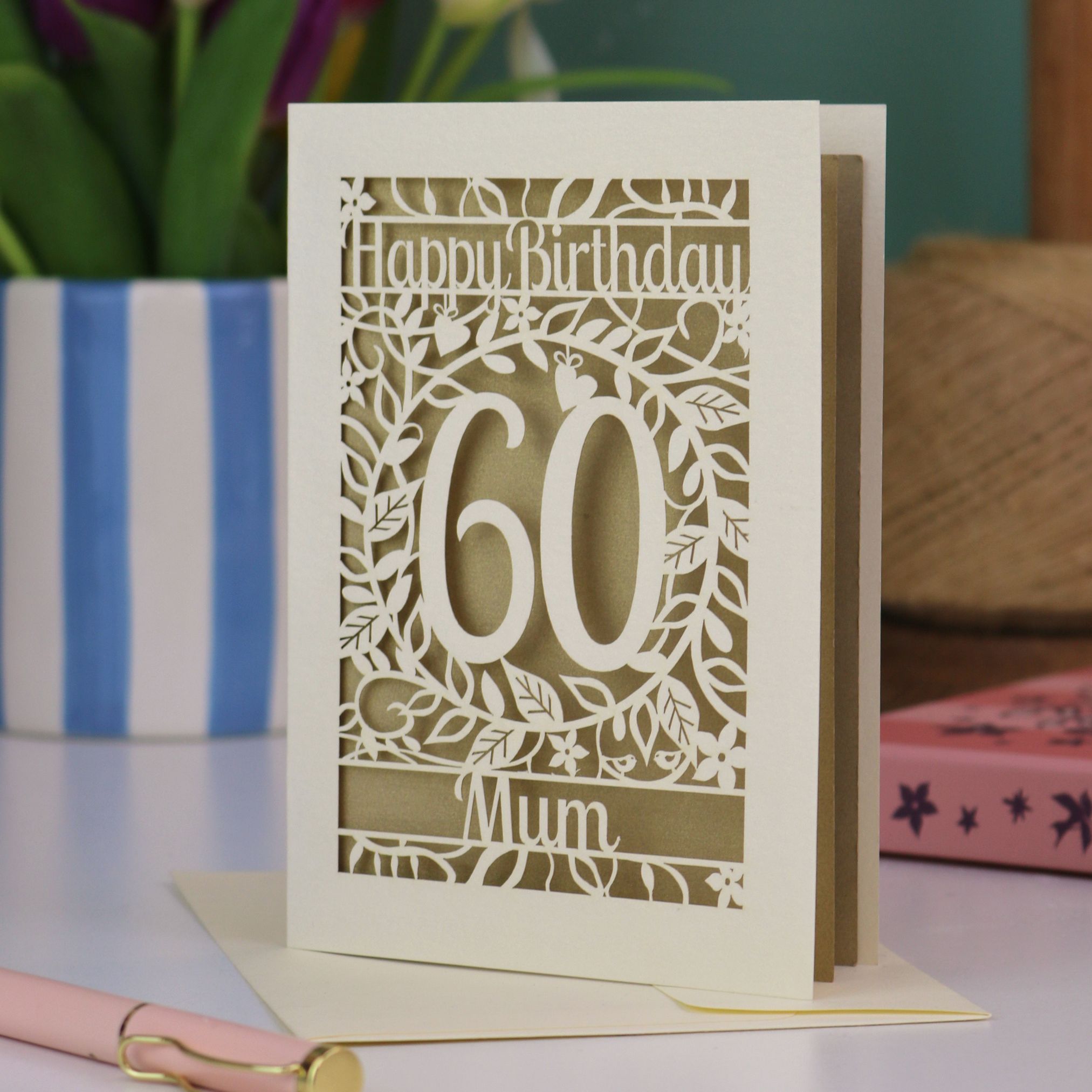 A laser cut Muim 60th birthday card with cut out floral border and "Happy Birthday" with a number 60 in the centre and personalised at the bottom with a name. 