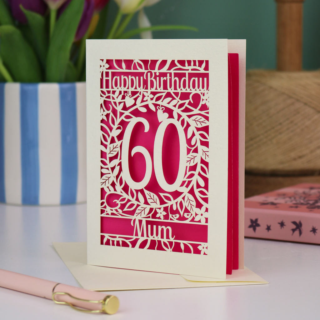 A laser cut 60th birthday card with cut out floral border and "Happy Birthday" with a number 60 in the centre and personalised at the bottom with a name. 
